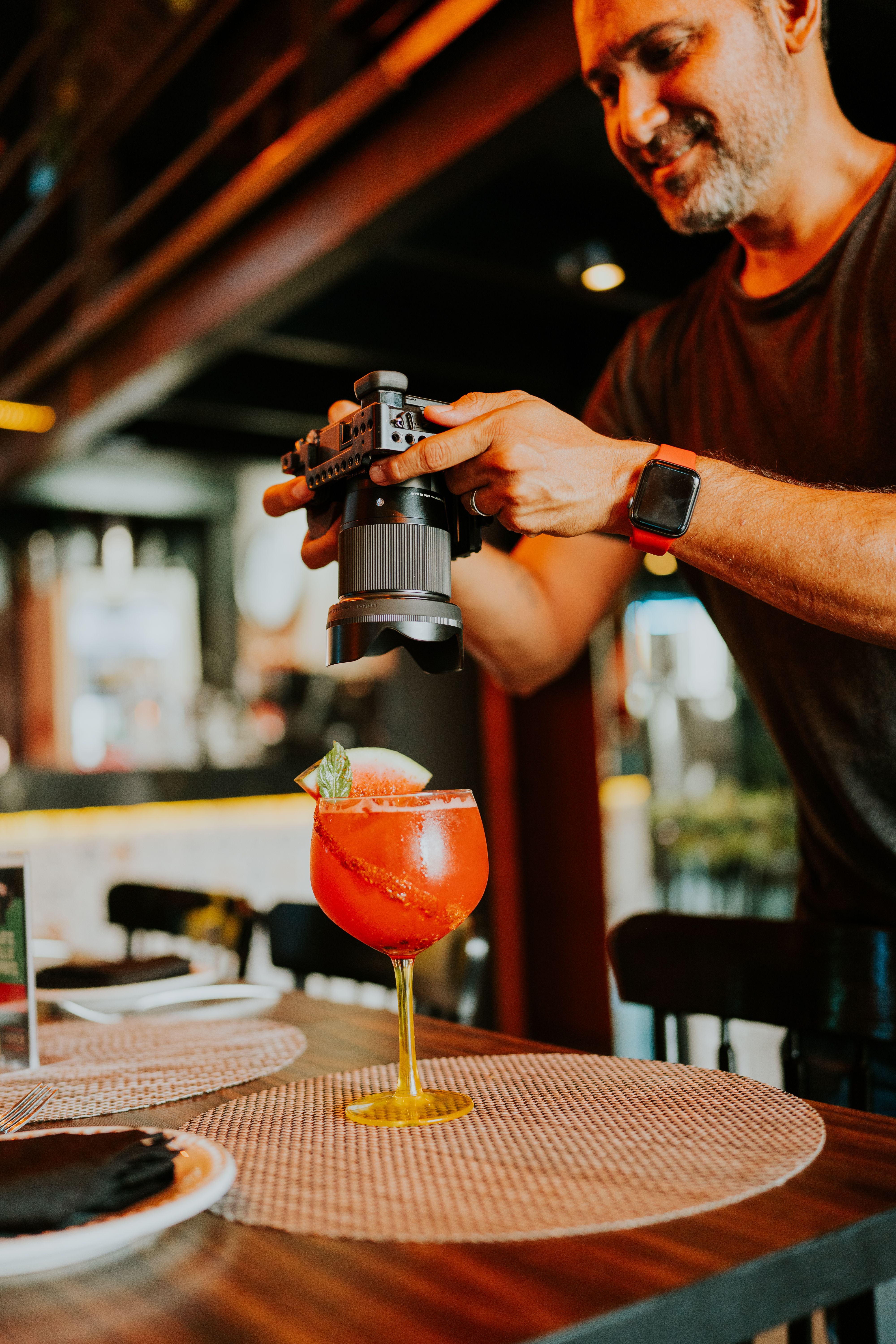 Photographer shooting a styled cocktail on a restaurant table